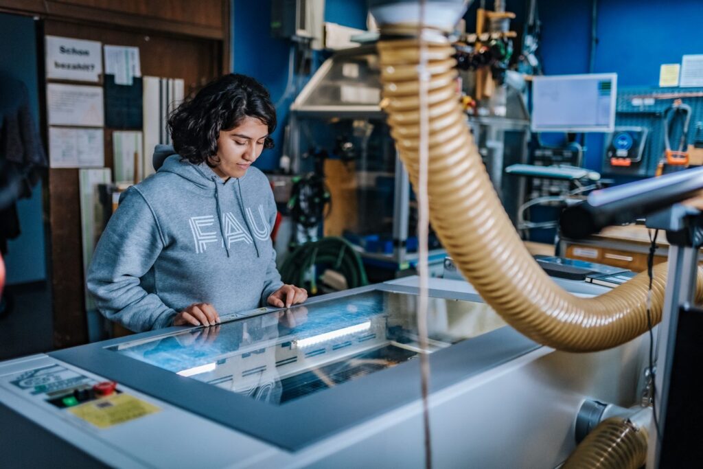 Person bedient den Lasercutter im FAU FabLab